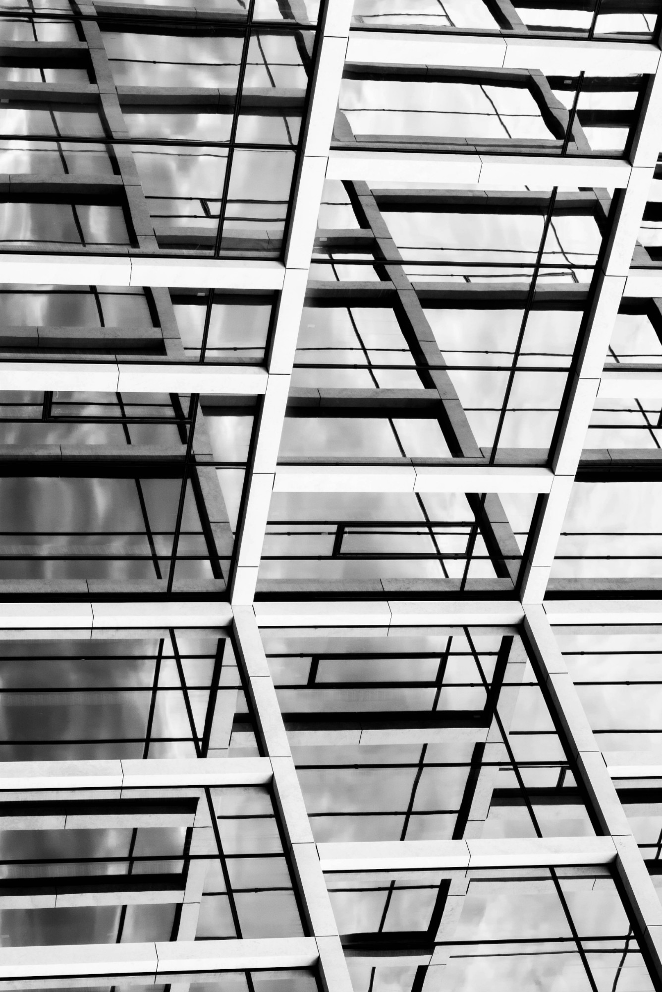 Detail of a glass and steel building facade, a grid of angular reflective windows