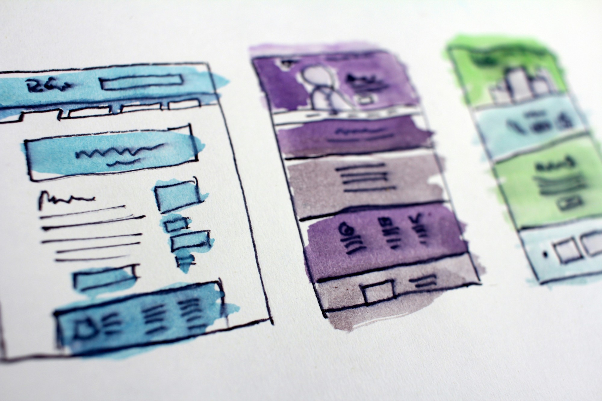 Watercolor and ink wireframe sketches of website pages